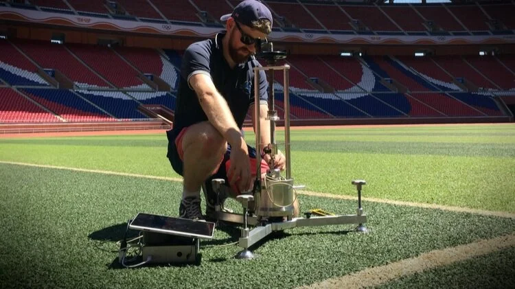 Sports Labs technician carrying out an impact test on a pitch inside a stadium