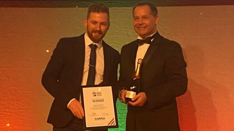 Two members of the Sports Labs team receiving an industry award certificate and trophy