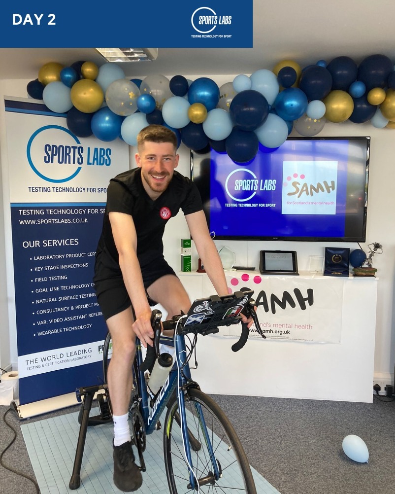 Visitor trying a demonstration on an exercise bike at the Sports Labs exhibition stand