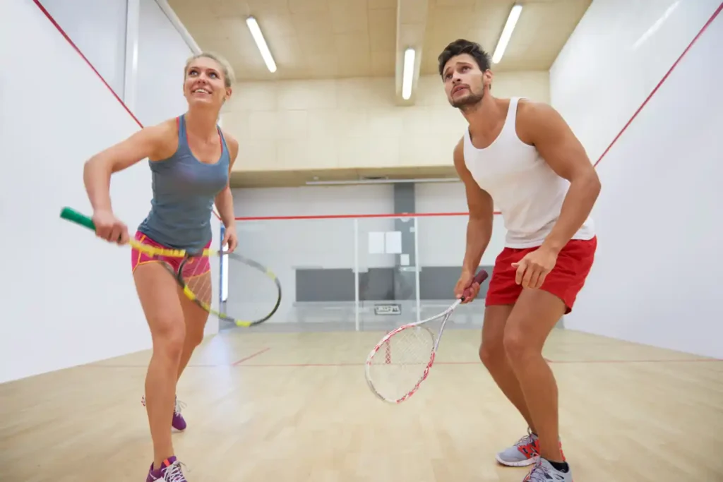 Two squash players with rackets on an indoor squash court