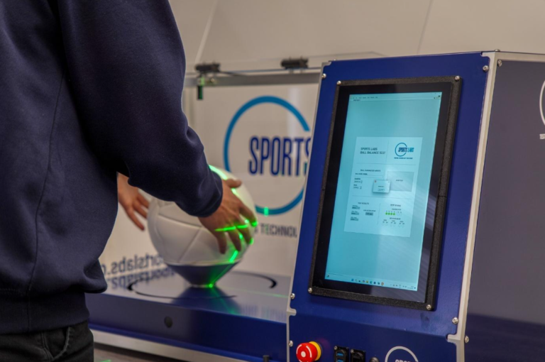 Hands operating the touchscreen on the Sports Labs Ball Balance Test Device