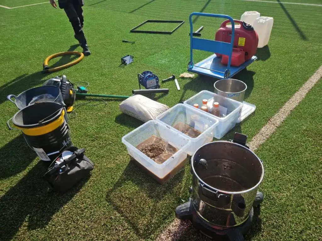 Test equipment and infill sample trays laid out on a grass pitch