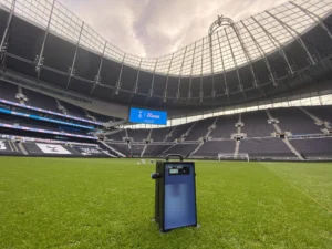Portable Sports Labs test device positioned on a stadium pitch with the scoreboard behind